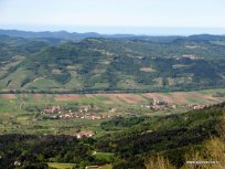 Panorama Budanj z romasko cerkvijo v Logu ob vznožju kraja.