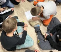 Na sliki je skupina otrok, ki opravlja na letovanju zadano nalogo.