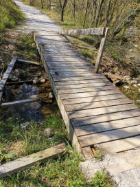 Poškodovan mostiček na pešpoti proti Lokavcu.